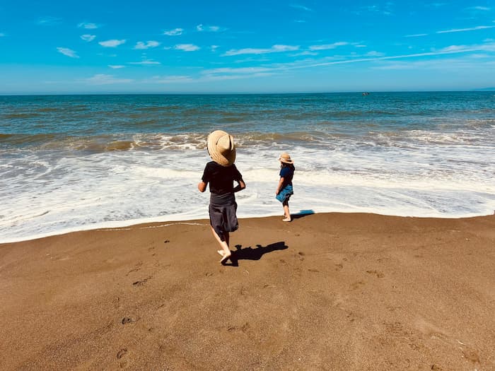 two kids at water's edge at the beach