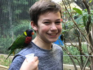 child with bird on shoulder