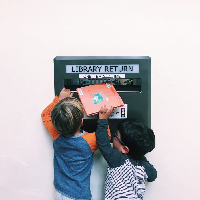 Kids putting books into the North Berkeley library return slot