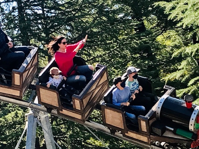 mom and kids riding roller coaster