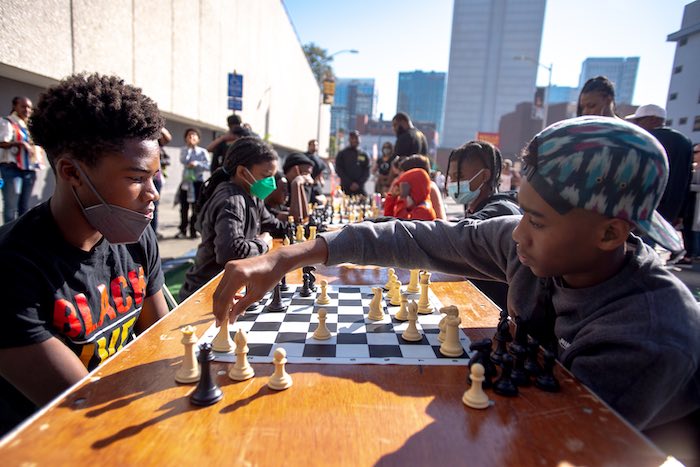 kids and adults play chess at Black Joy Parade in Oakland