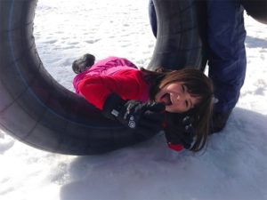 child in a tube in the snow. scarlett