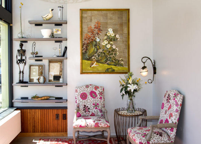 Entry way with painting of flowers and two pink floral chairs at Glow Birth & Baby Oakland