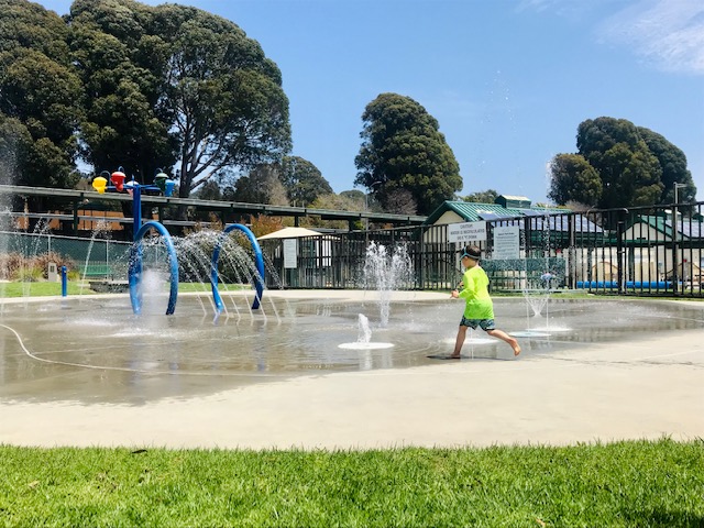 child running in splash park