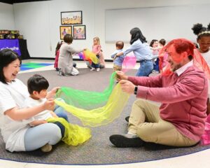 families and children playing with scarves