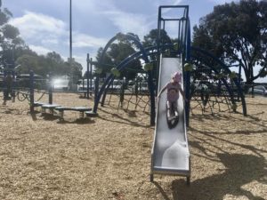 Child moves down slide at playground