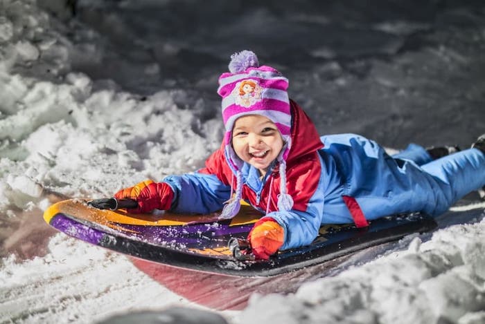 kid sledding in the snow