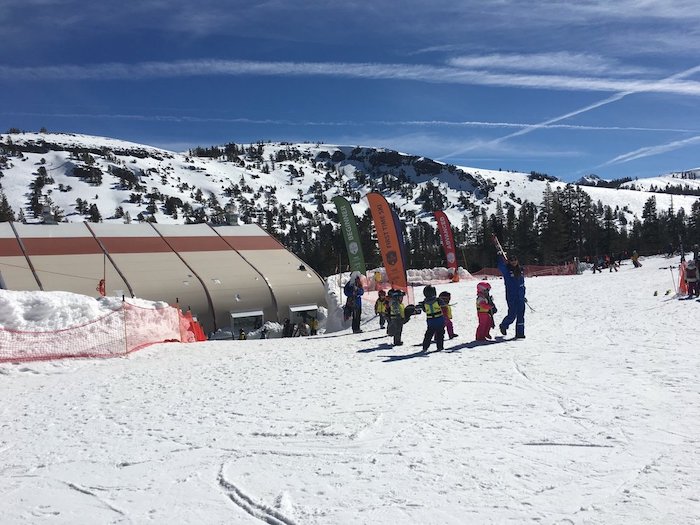 South Lake Tahoe Ski School Smackdown 2 small children holding skis at group lesson at Kirkwood