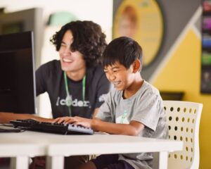 code coach and student laughing at the coder school