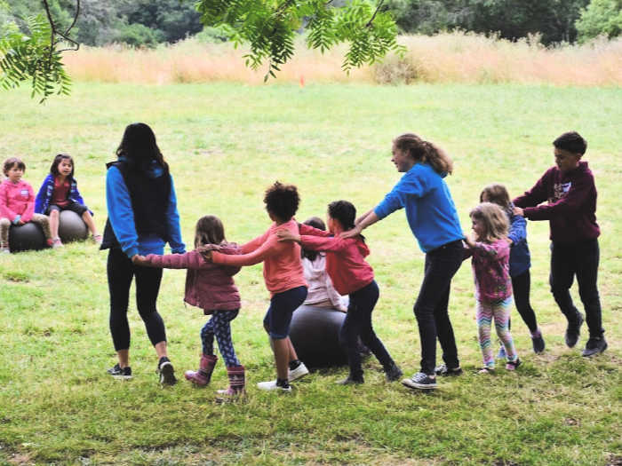 Kids dance in the field at Monkey Business camp