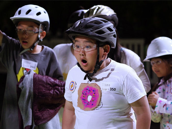 surprised child wearing bike helmet in a group of others