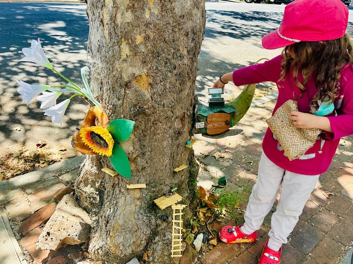 little girl opening fairy house door