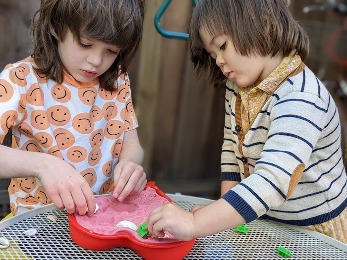 two children playing with dough in a heart