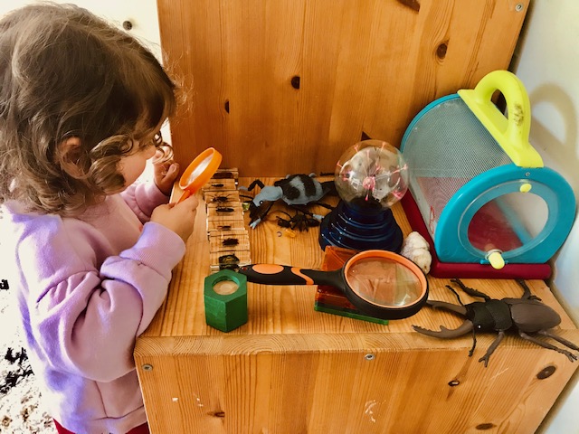 toddler looking through magnifying glass