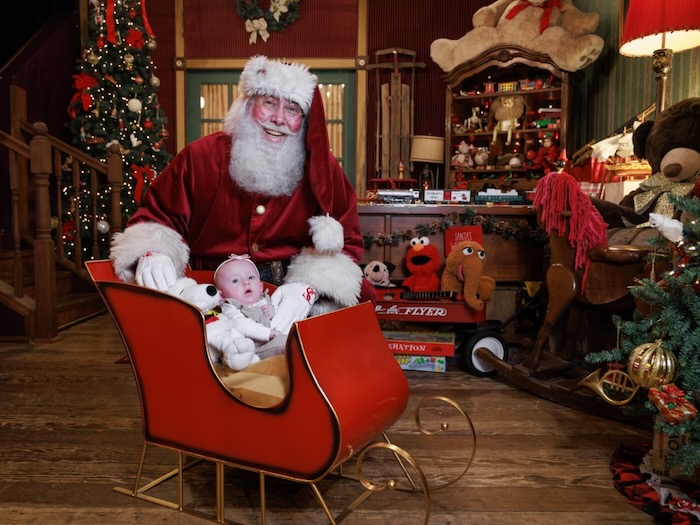 santa claus and kids in christmas workshop building with blocks