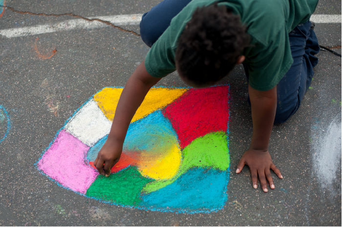 student drawing with sidewalk chalk