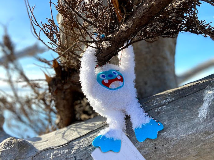 abominable snowman yeti hanging from a tree