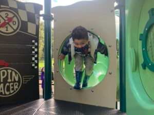 kid playing in dimond park tot lot spin racer
