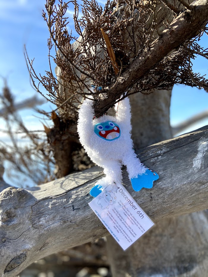 abominable snowman stuffie hangs from a tree