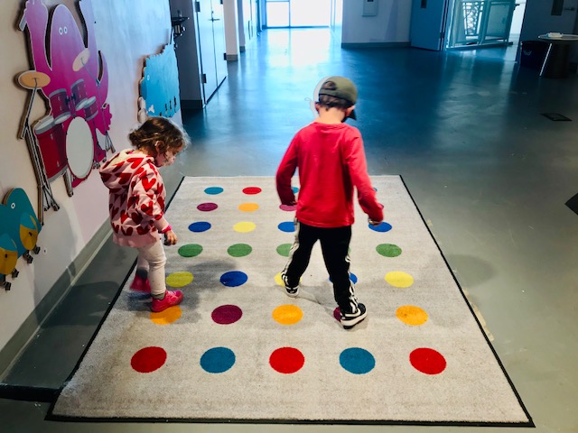 kids walking on colorful dot rug