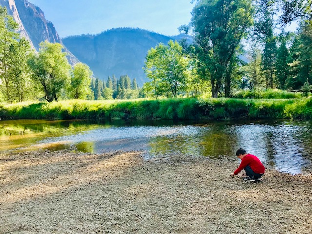 Child playing by river in Yosemite