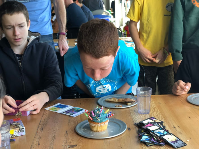kid blowing on cupcake