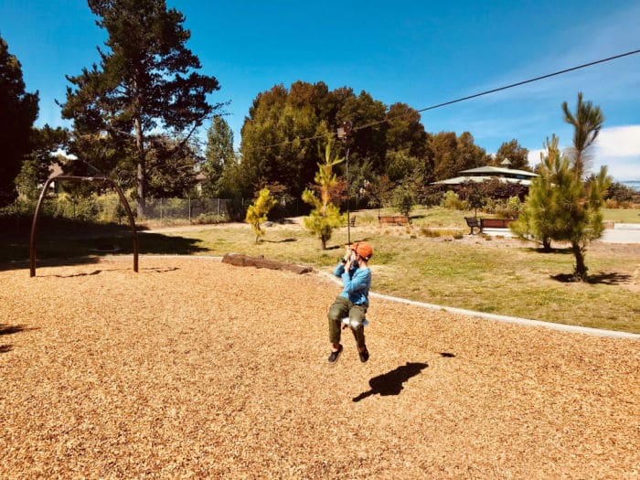 child on playground zipline
