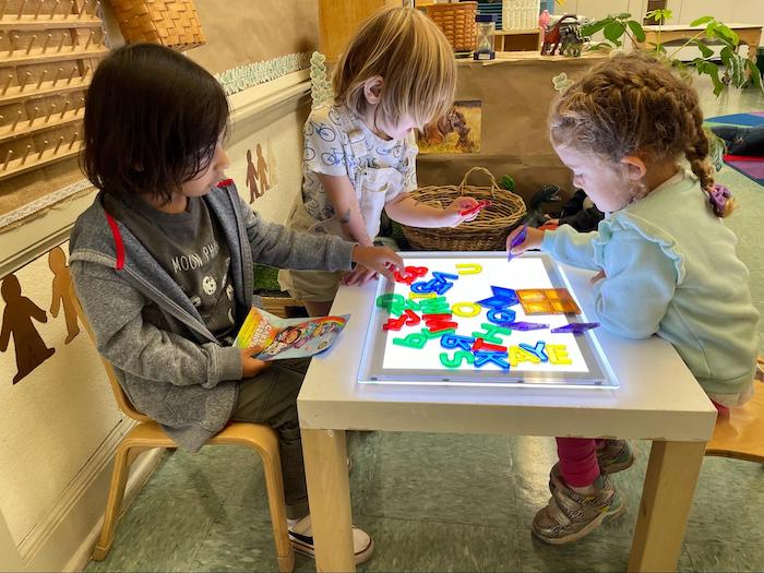 four year olds play with colorful letter tiles