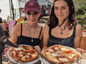 Helena and sister holding pizzas from Cafe Reyes in Point Reyes Station