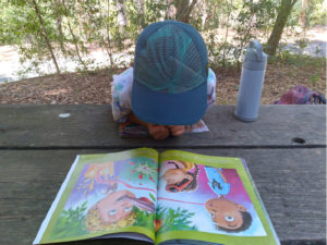 child reading book outside