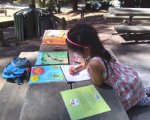 child reading and writing outdoors