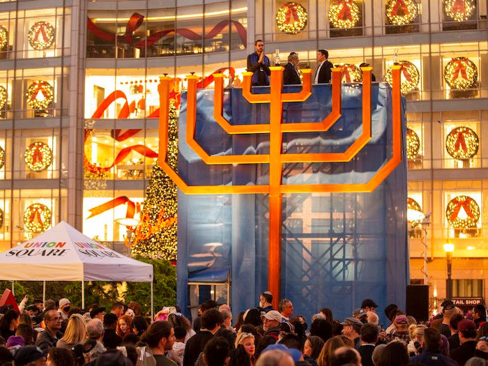 Large constructed menorah in front of Macy's windows