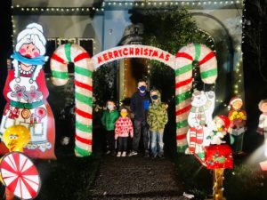 kids under candy cane Christmas display