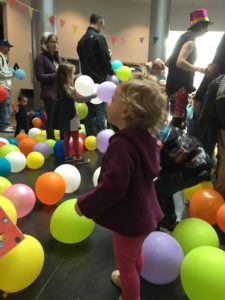 Child standing among balloons at kid-friendly New Year's Eve celebration