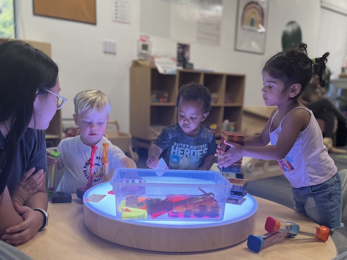 children playing at a light and shape table