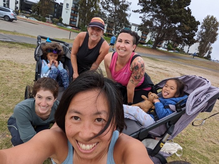 moms jog with strollers and little kids posing for selfie