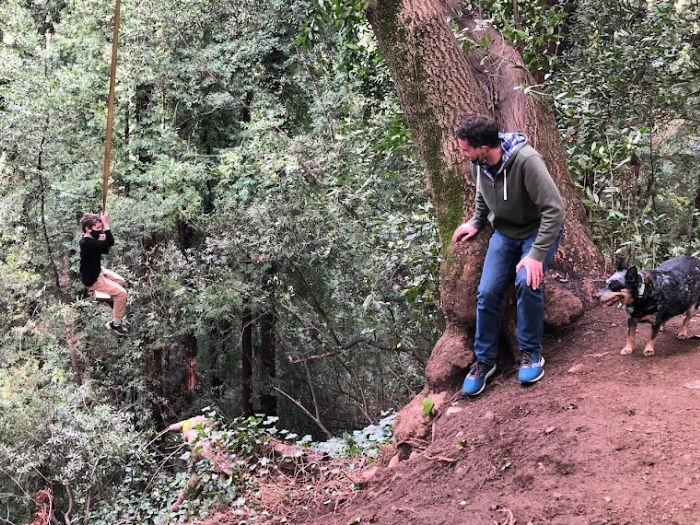 kid on a rope swing over a canyon - nervous dad looks on
