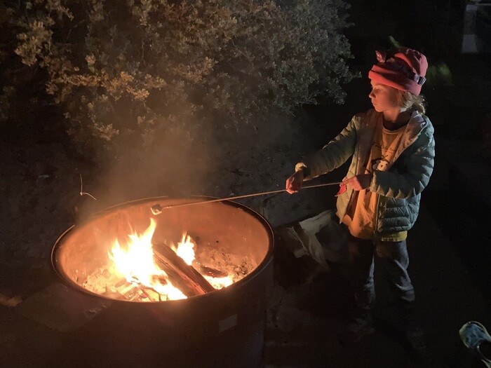 Child making smores over campfire