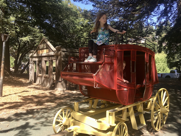 red climbing structure with children on and in it