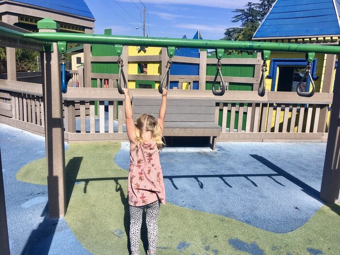 Matteo's Dream Playground, Inclusive Fun in Concord 5 Child hangs on monkey bars at all-abilities playground