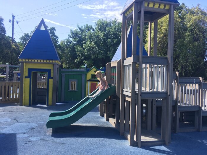 Child goes down slide at toddler park