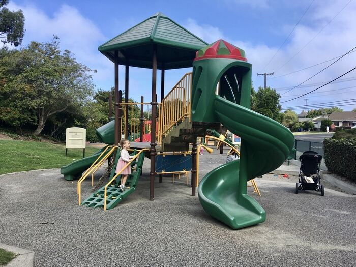 Child climbs up ladder at playground