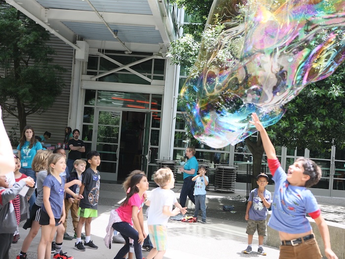 children dance among bubbles