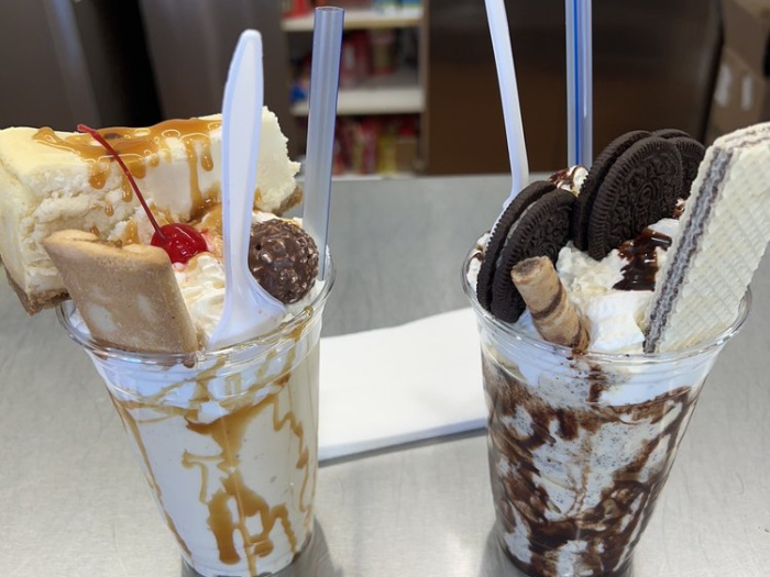 two milkshakes piled high with toppings