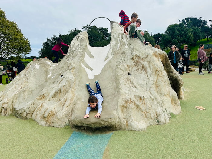 child sliding head first down slide