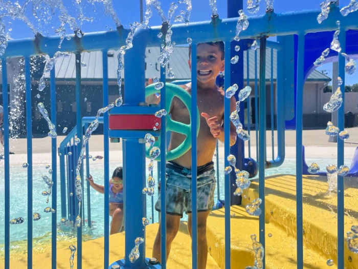Best Things to Do in San Leandro With Kids 1 kid on a sprayground controlling the water jets
