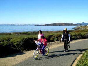 family biking and walking along SF Bay