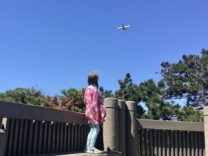 Child spots plane overhead at Coyote Point