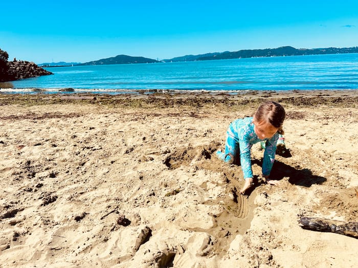 child playing in sand at beach