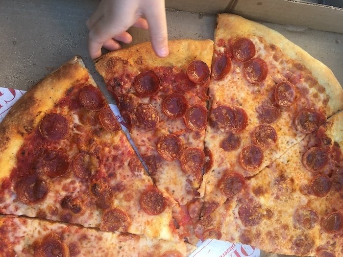 Kid grabbing a slice of Gioia pizza